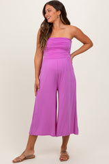 woman wearing a pink strapless maternity jumpsuit with a gathered bodice and wide-leg pant style