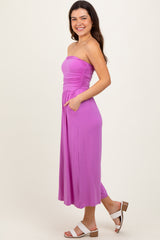 woman wearing a strapless lavender maxi dress with ruching at the bodice and pockets, standing sideways