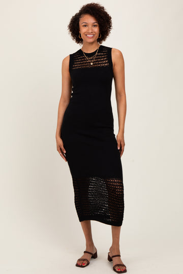 woman wearing a black sleeveless knit midi dress with open weave detailing and strappy sandals