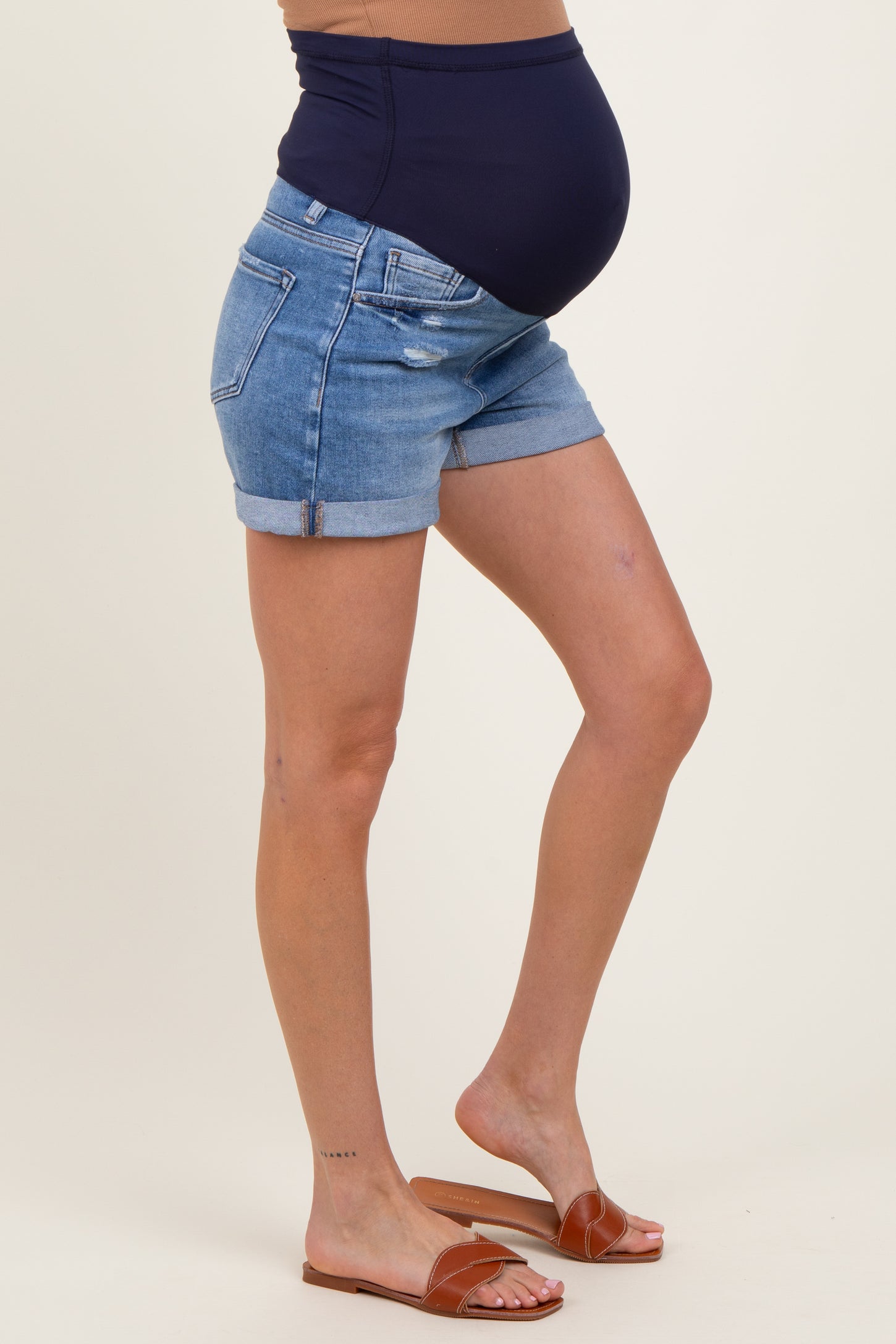 woman wearing dark blue maternity shorts with a stretchy waistband and a visible baby bump