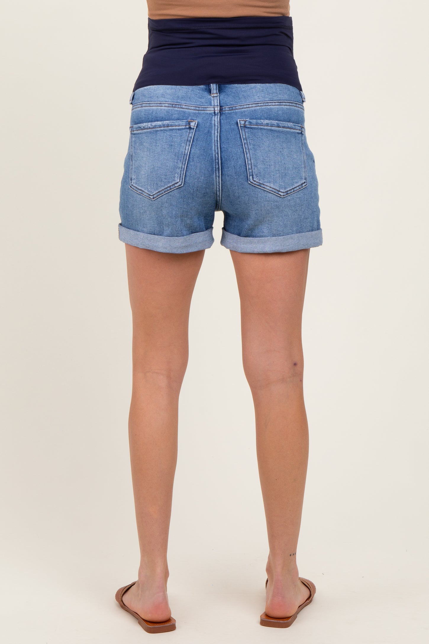woman wearing light blue maternity denim shorts, showing rolled cuffs and a comfortable waistband, back view