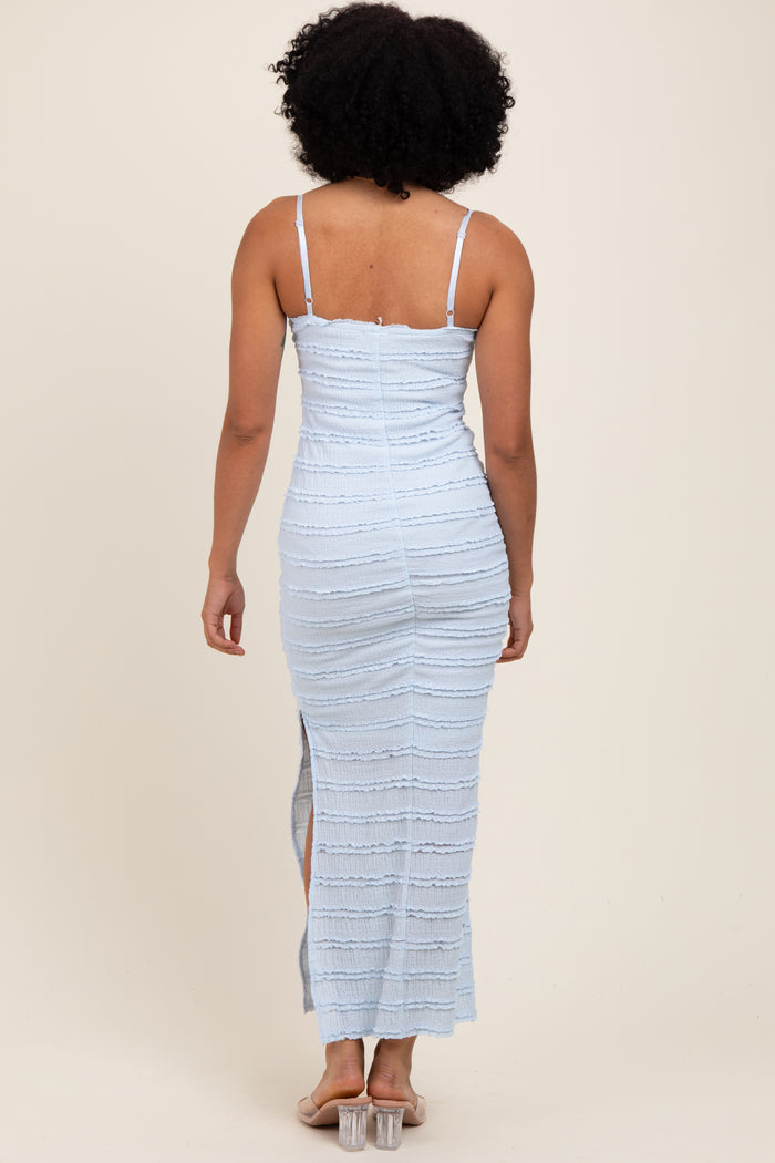 woman wearing a light blue fitted maxi dress with spaghetti straps and side slit, viewed from the back