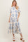 woman wearing a blue and white floral print midi dress with short sleeves and a button-up neckline