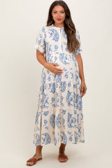 woman wearing a cream and blue floral print maternity maxi dress with a button front and baby bump visible