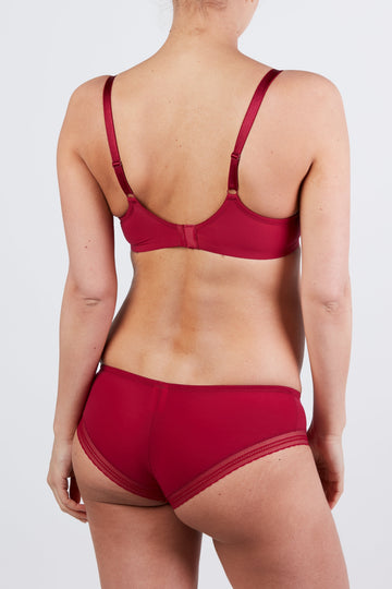 woman wearing a maroon maternity bra and matching panties, view from the back