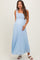 woman wearing a light blue maternity maxi dress with tie straps and a flowing skirt, showing her baby bump