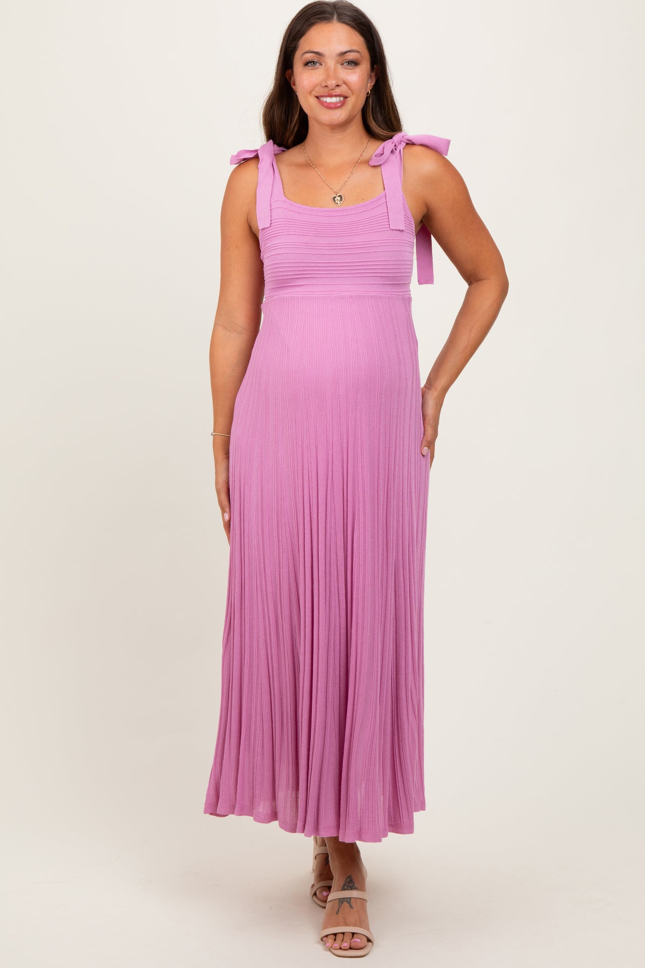 woman wearing a light purple maternity maxi dress with tie straps and a flowy skirt, displaying a baby bump