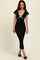 woman wearing a black fitted midi dress with short sleeves and white trim details, posing confidently