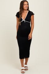 woman wearing a black maternity dress with white tie detail and short sleeves, showcasing her baby bump