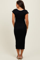 woman wearing a black maternity midi dress with cap sleeves and lace details, showing her baby bump from the back