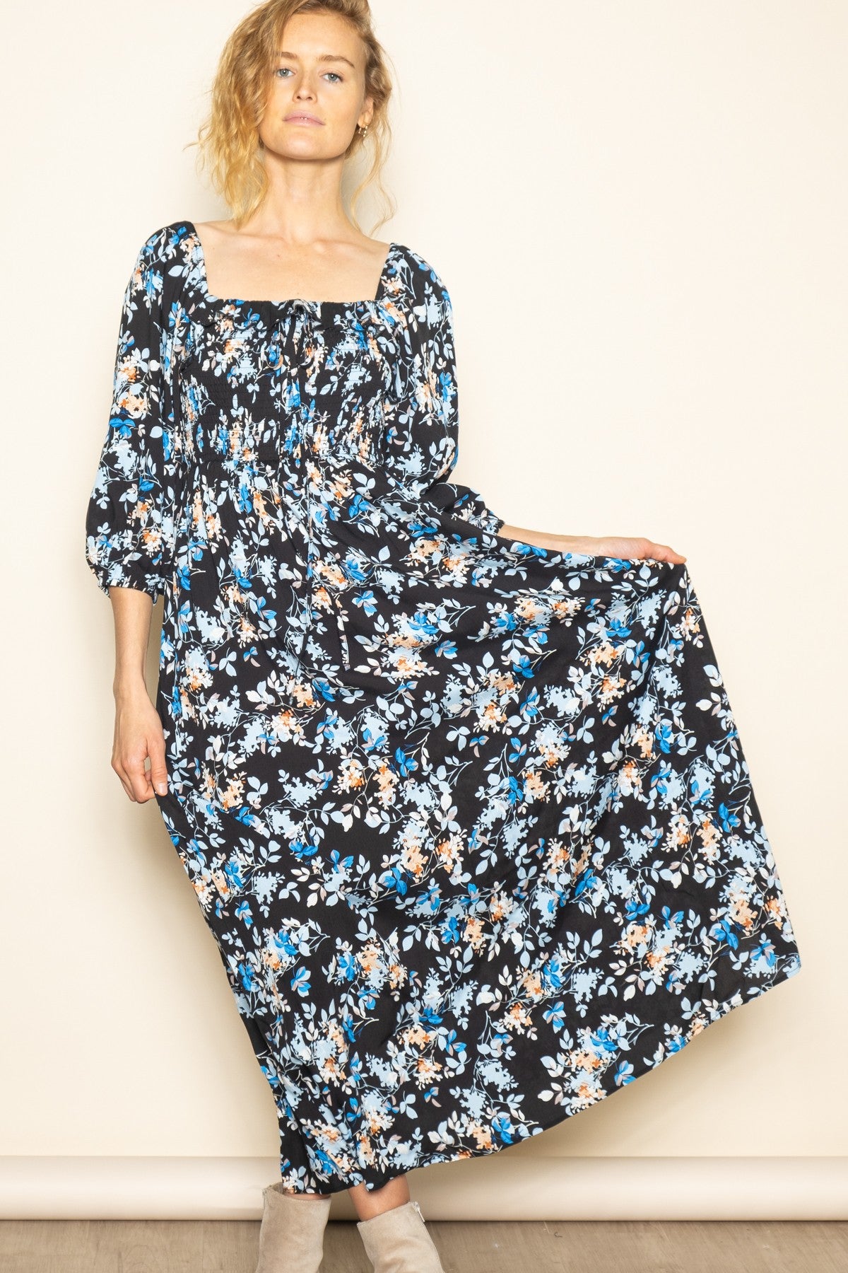 woman wearing a black floral maxi dress with a square neckline and puff sleeves