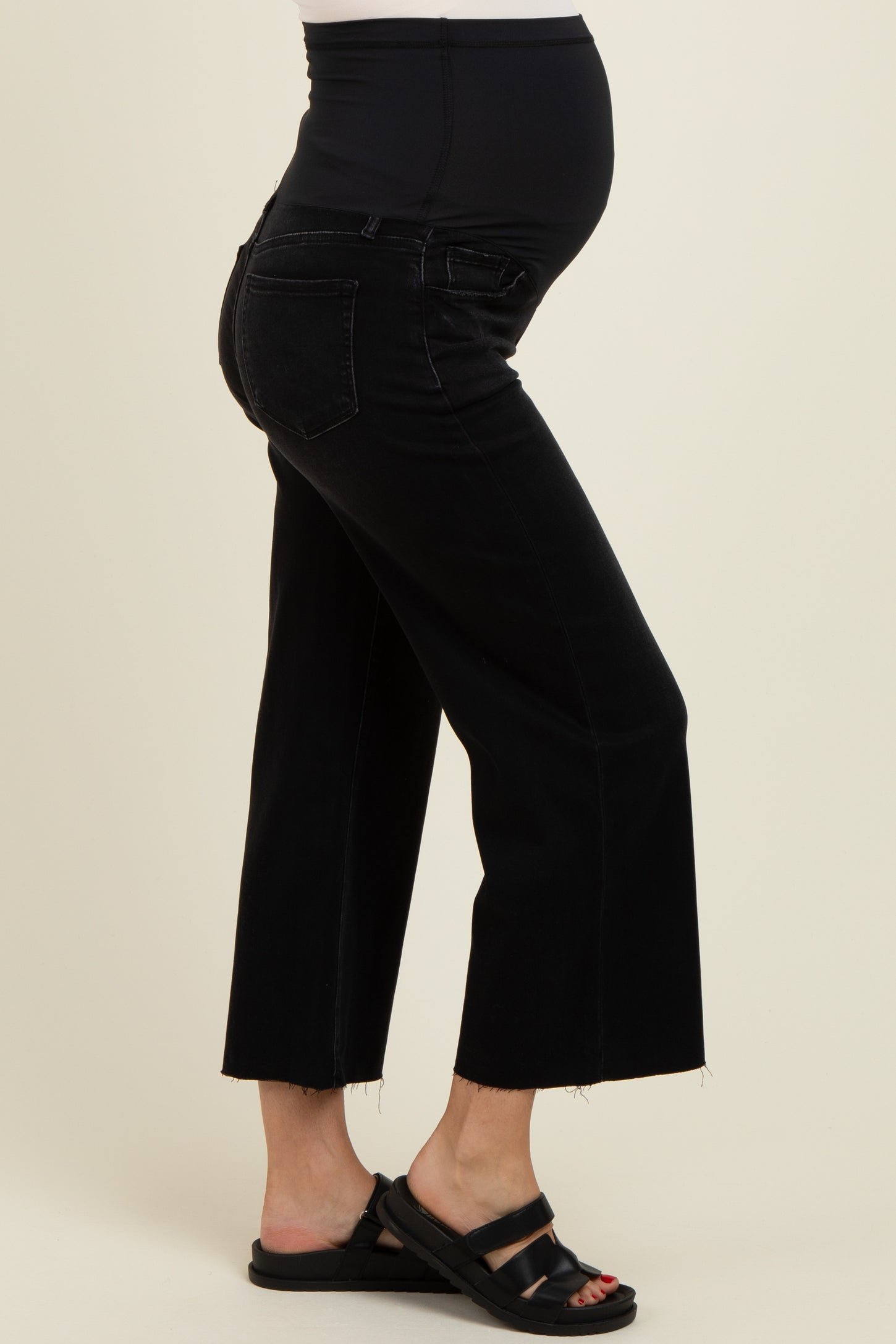 maternity wear black cropped maternity jeans with a high waistband and frayed hem, model showcasing a baby bump