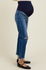 woman wearing distressed blue maternity jeans with a supportive belly band, showcasing her baby bump