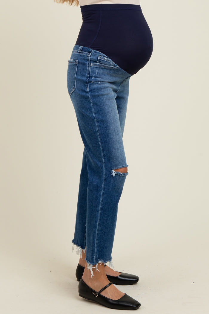 woman wearing distressed blue maternity jeans with a supportive belly band, showcasing her baby bump