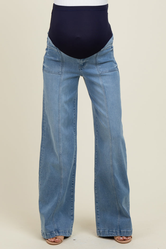 maternity wear in light blue wide leg jeans with a dark blue over-the-bump panel, model standing with bare feet