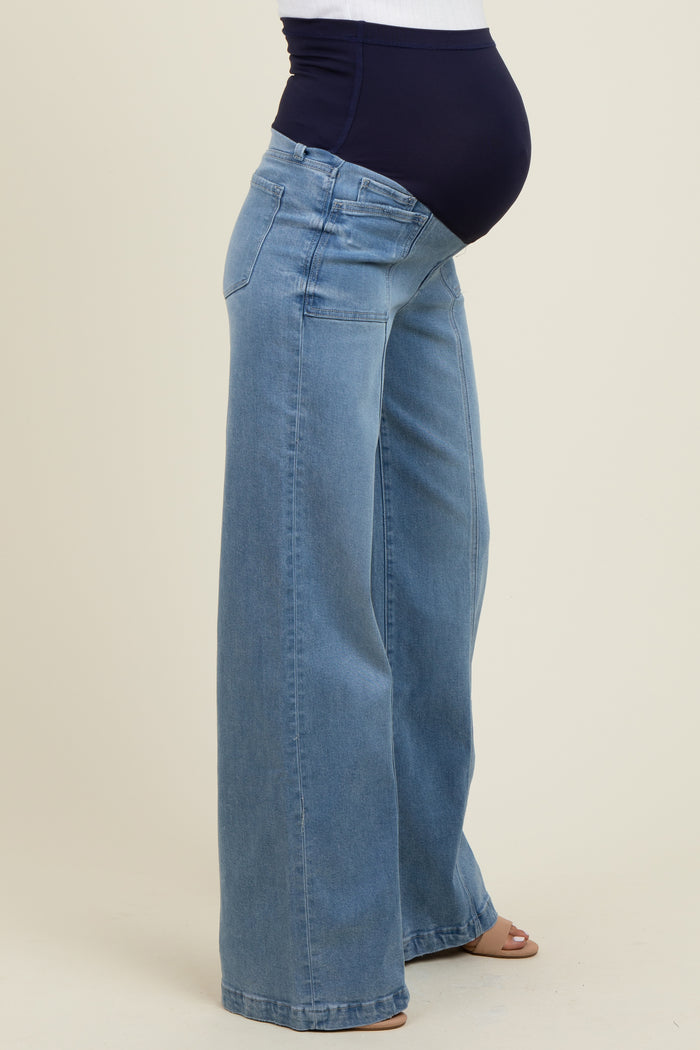 woman wearing light blue wide-leg maternity jeans with a dark blue waistband and visible baby bump