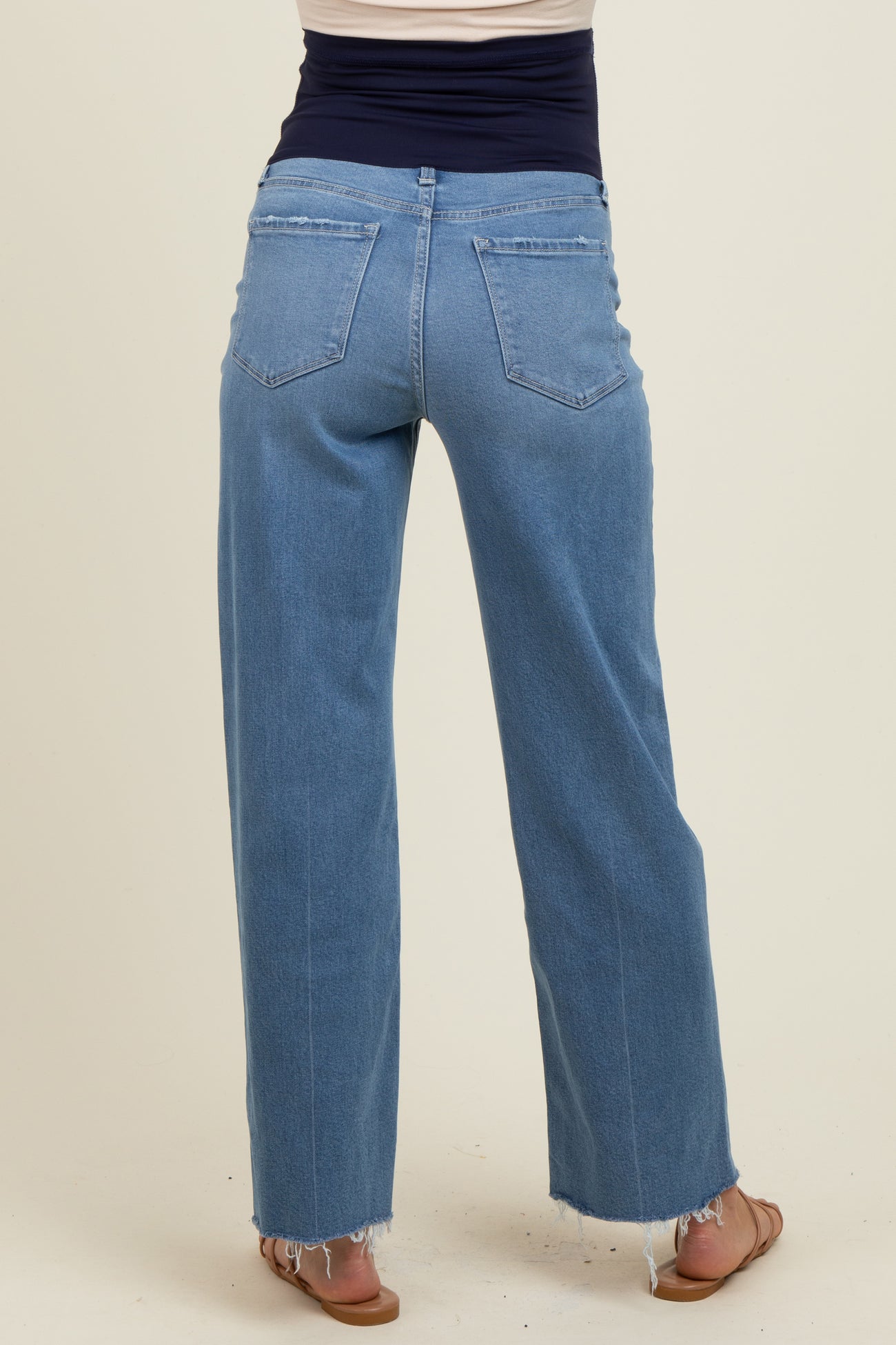 woman wearing light blue maternity wide-leg jeans, showing the back and hem detailing