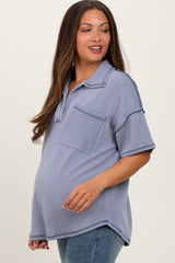 woman wearing a blue striped maternity polo shirt with a front pocket and a visible baby bump