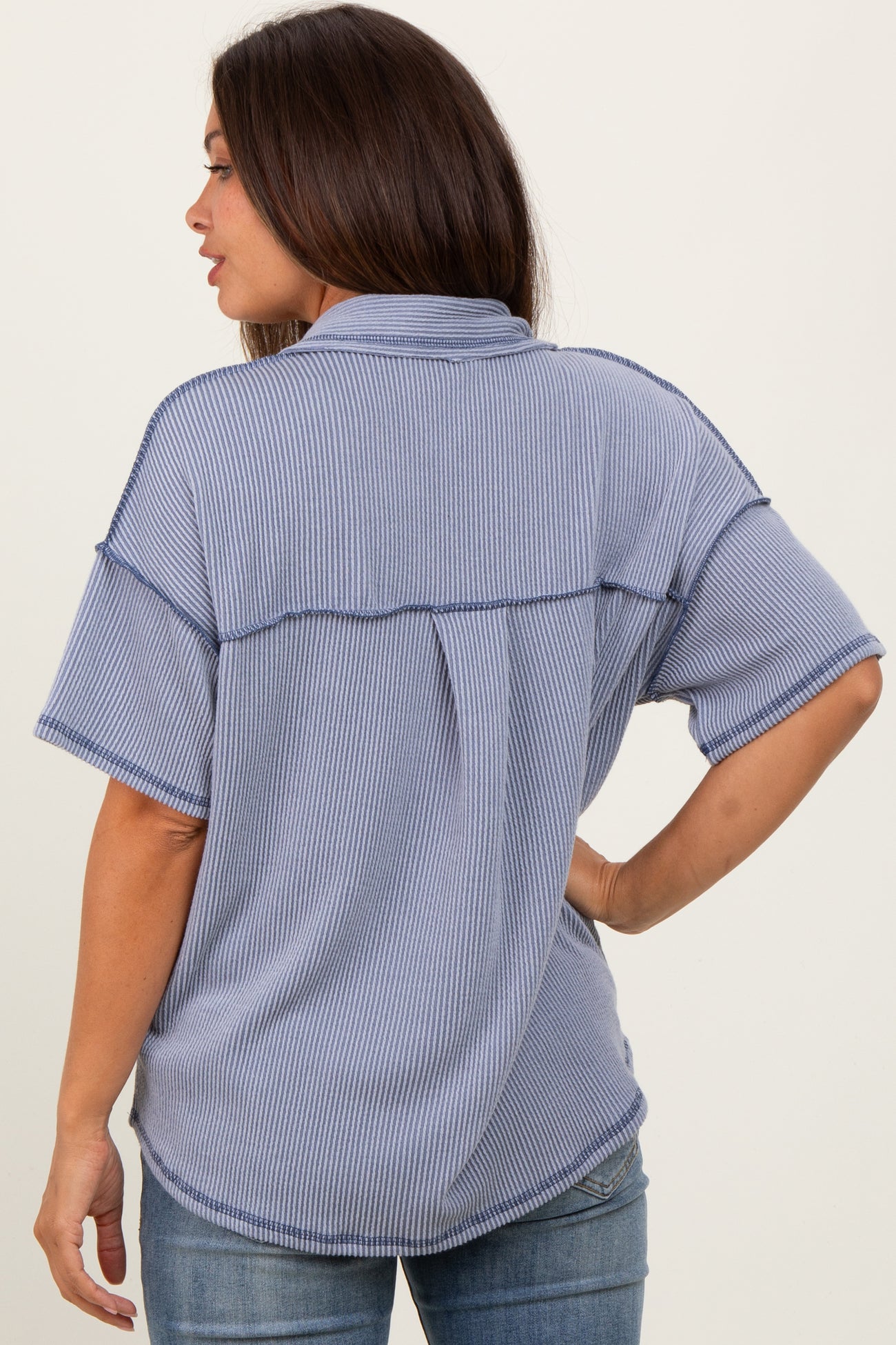 woman wearing a relaxed fit blue striped maternity top, showing a back view and casual style