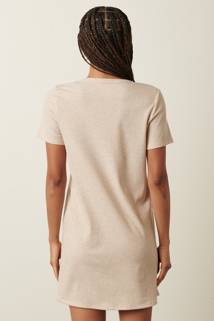 woman wearing a beige short sleeve ribbed dress seen from the back