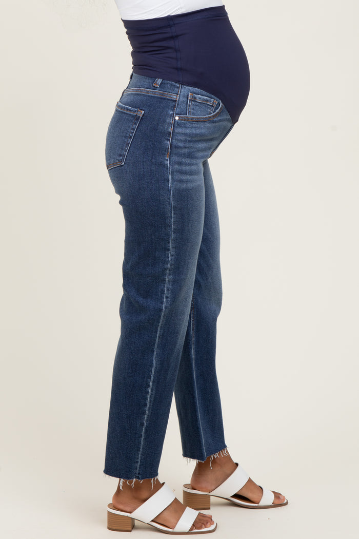 woman wearing a pair of blue maternity jeans with a navy belly band and frayed hem, showing her baby bump
