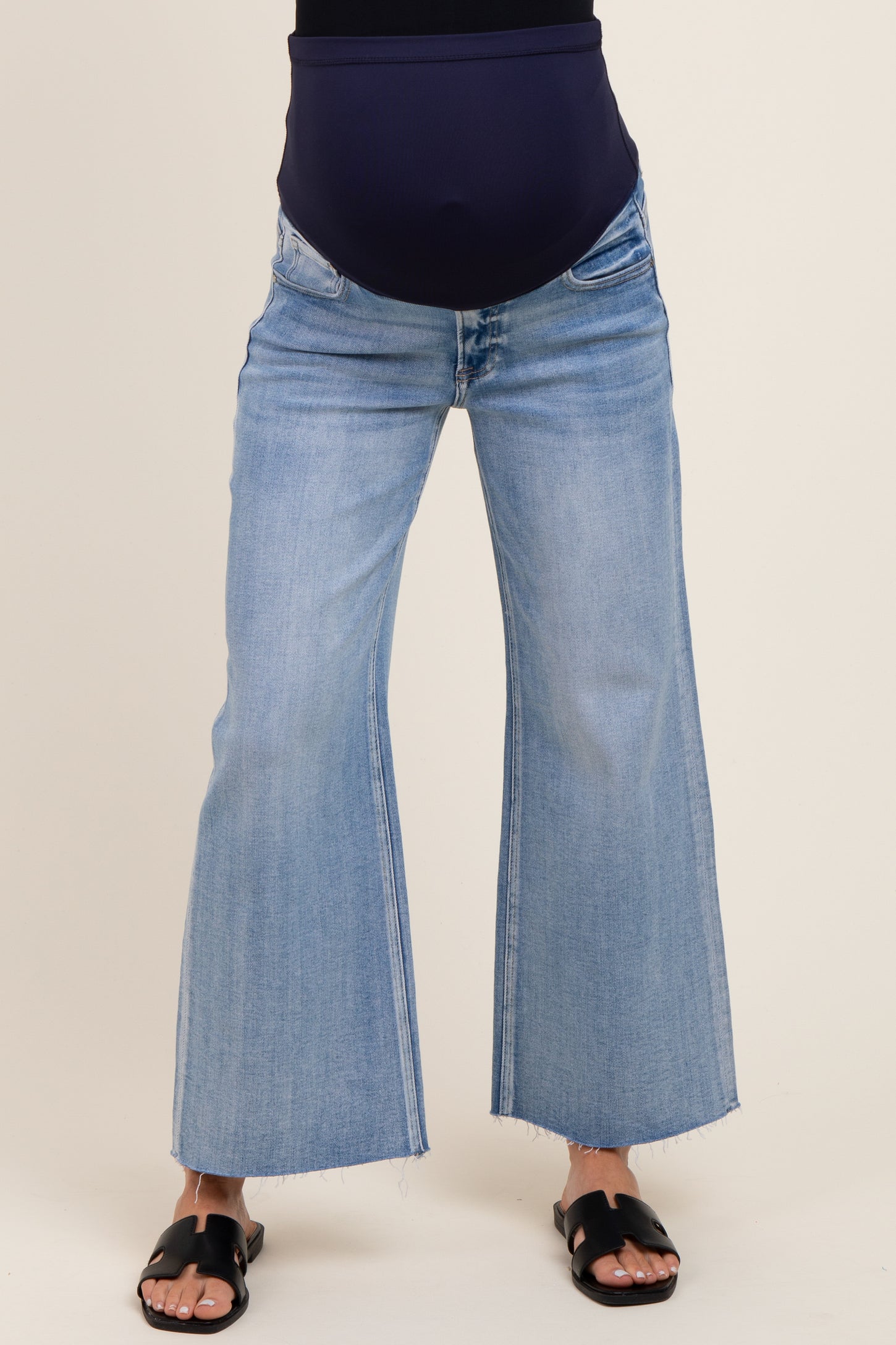 woman wearing light blue maternity flared jeans with a dark blue over-the-bump waistband