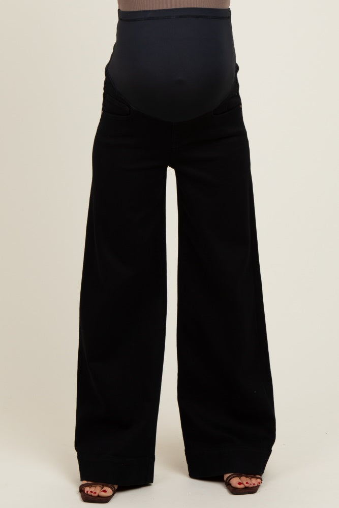 woman wearing black wide-leg maternity pants with a supportive belly band