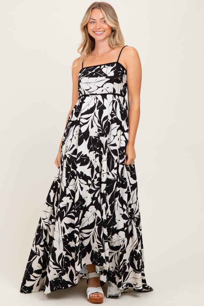 woman wearing a black and white floral maxi dress with a square neckline and spaghetti straps