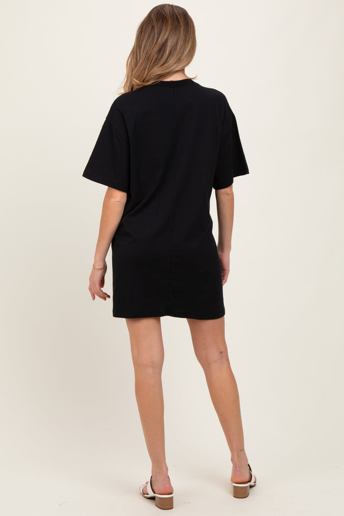 woman wearing a black short sleeve maternity dress, standing with her back to the camera