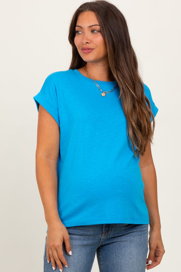 woman wearing a bright blue maternity top with short sleeves and a relaxed fit, gently highlighting her baby bump