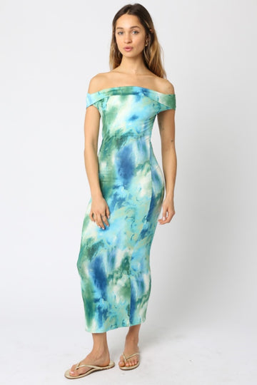 woman wearing a blue and green off-the-shoulder maxi dress with a fitted silhouette and a tie-dye pattern