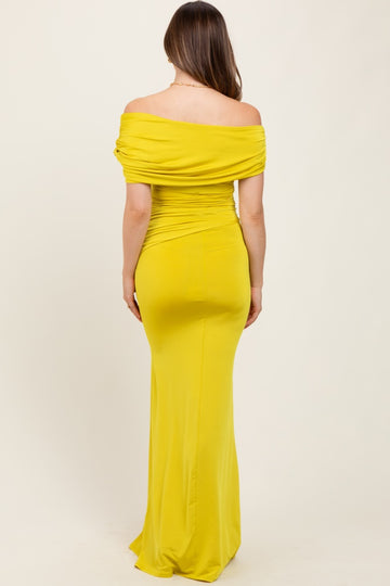 woman wearing a bright yellow off-the-shoulder maternity gown with a fitted silhouette visible from the back