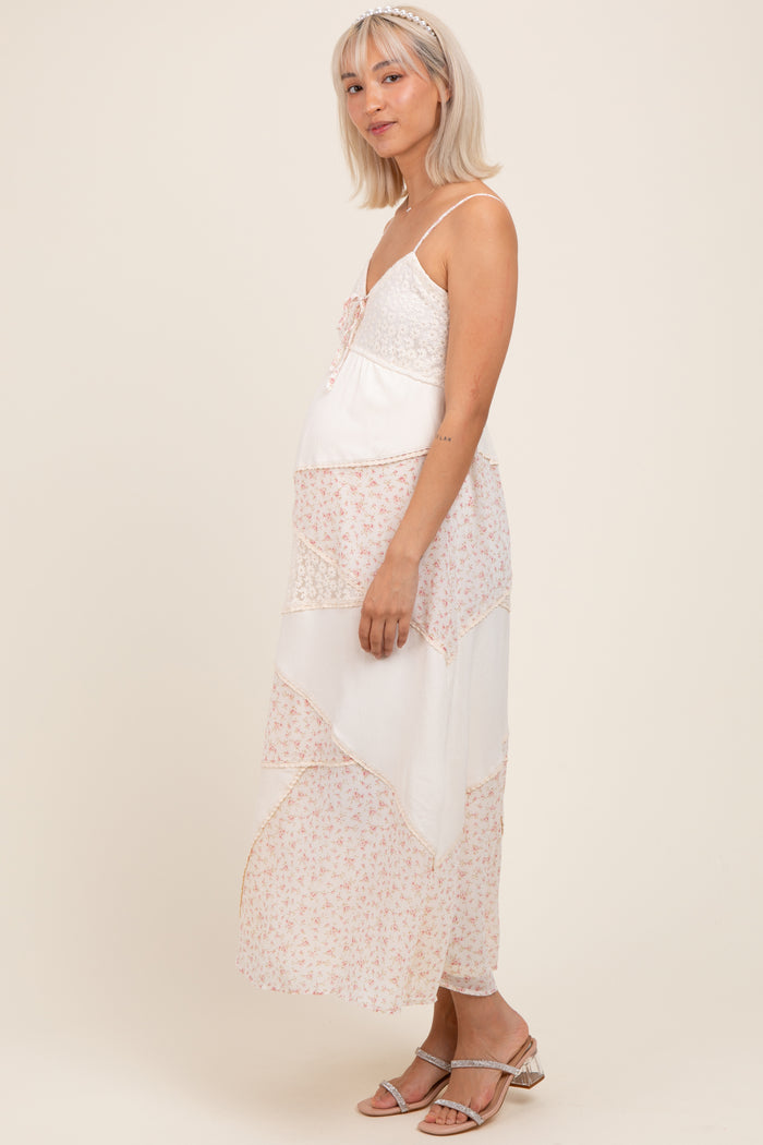 woman wearing a floral patterned maternity maxi dress with lace details and a visible baby bump