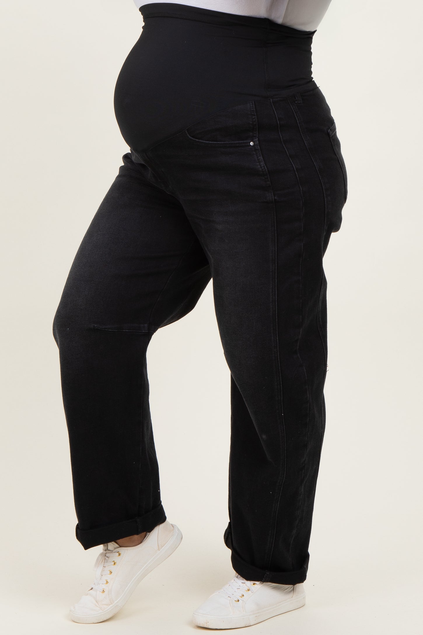 woman wearing black maternity plus jeans with a stretchy waistband, showcasing a visible baby bump