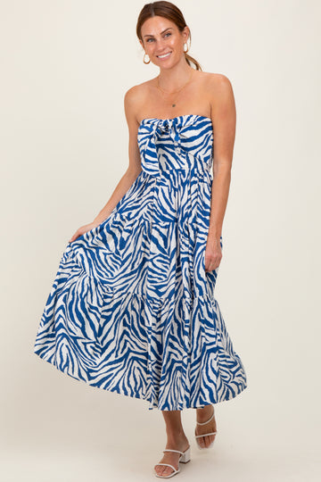 woman wearing a strapless blue and white zebra print maxi dress with a tie front detail