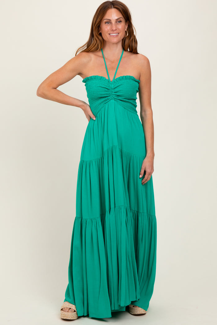 woman wearing a green halter maxi dress with smocked bodice and tiered skirt