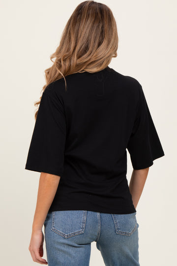 woman wearing a black maternity t-shirt from the back with wide sleeves and styled with denim jeans