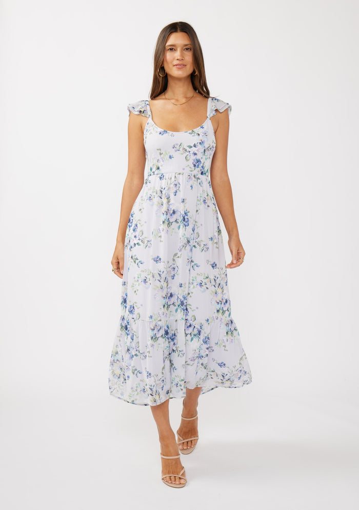 woman wearing a white floral maxi dress with cap sleeves and a fitted bodice