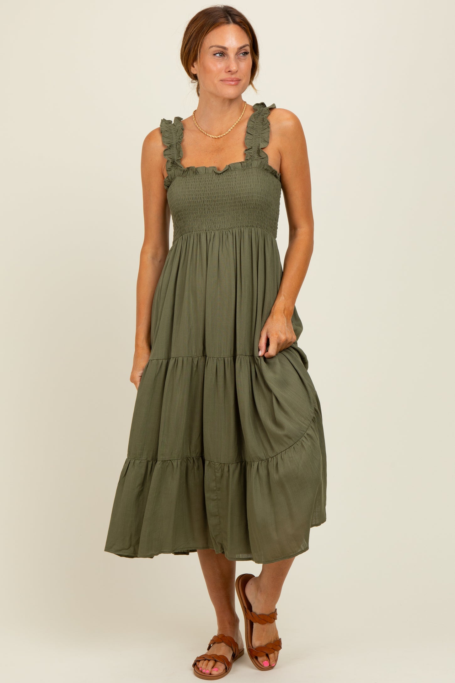 woman wearing an olive green tiered maxi dress with ruffle straps and a smocked bodice