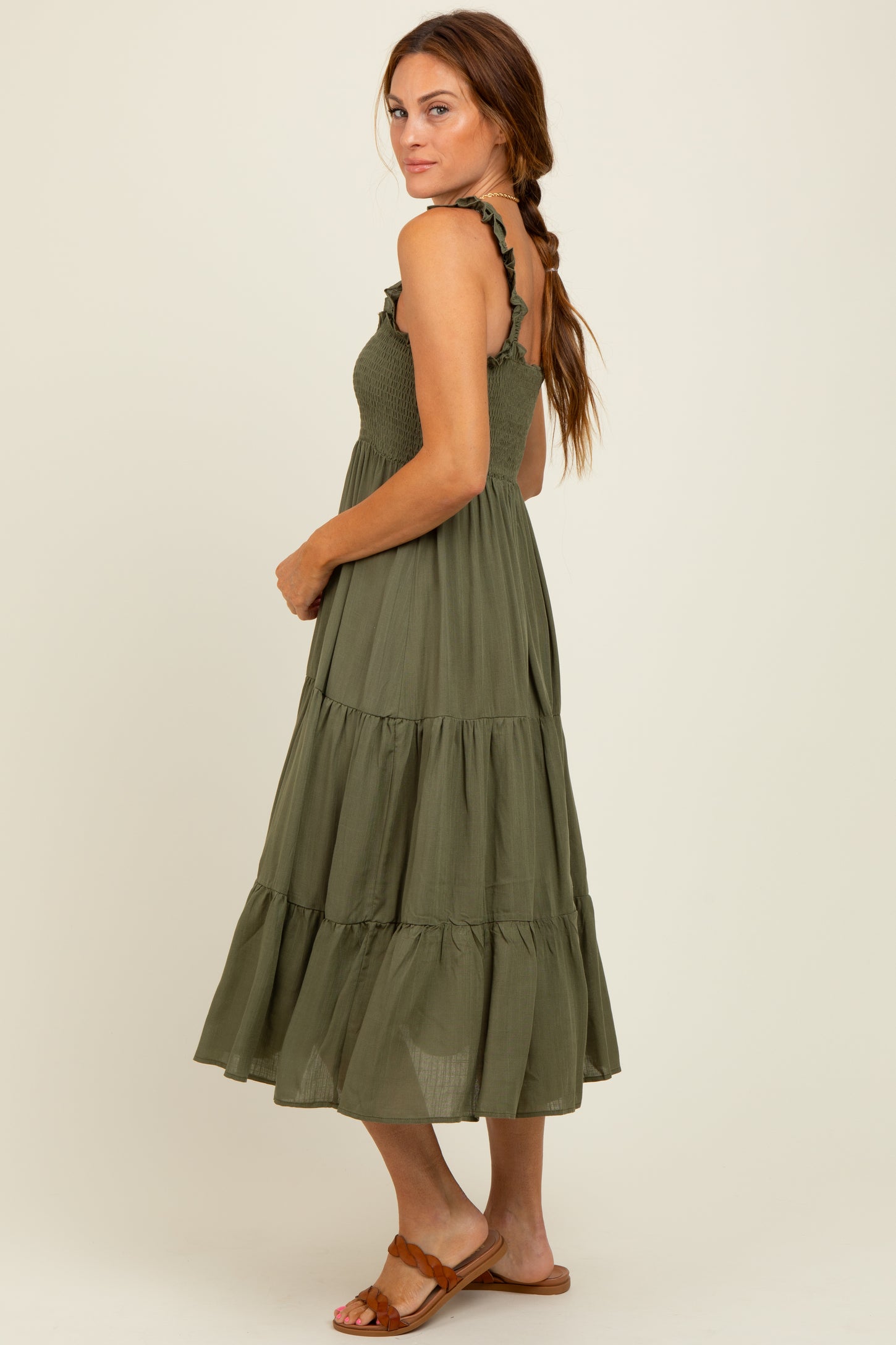 woman wearing an olive green tiered maxi dress with ruffled straps and a fitted bodice