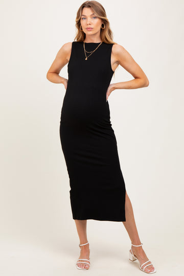 woman wearing a black ribbed maternity dress with a side slit and a fitted silhouette, showcasing her baby bump