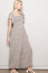 woman wearing a gray floral maxi dress with flutter sleeves and a square neckline