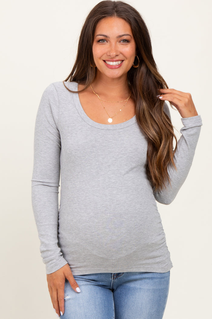 woman wearing a gray long sleeve maternity top with a scoop neckline and a visible baby bump