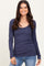 woman wearing a navy long sleeve ribbed top with a scoop neckline and smiling