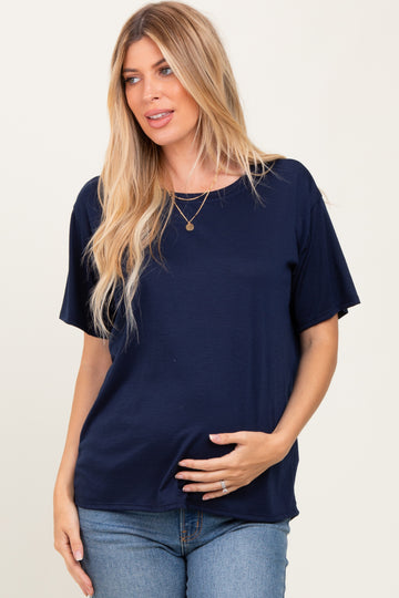 woman wearing a navy blue short sleeve maternity top and holding her baby bump