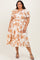 woman wearing a white plus size dress with orange floral print and puff sleeves, standing with hands on hips