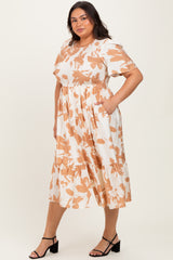 woman wearing a white plus size dress with a peach floral print and puff sleeves, standing with pockets and wearing strappy sandals