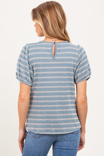 woman wearing a blue striped maternity top with puff sleeves and a keyhole back detail