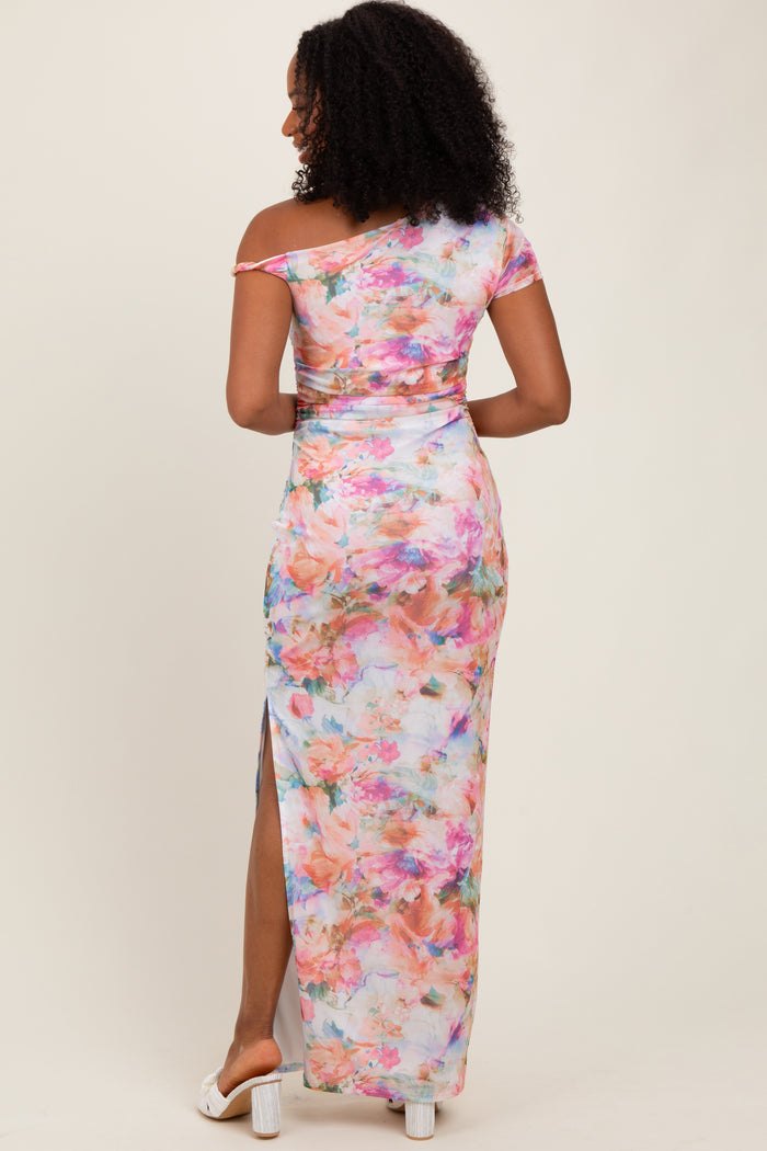 woman wearing a colorful off-shoulder maxi dress with a floral print and a side slit
