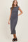 woman wearing a gray sleeveless midi dress with a straight silhouette and side slit